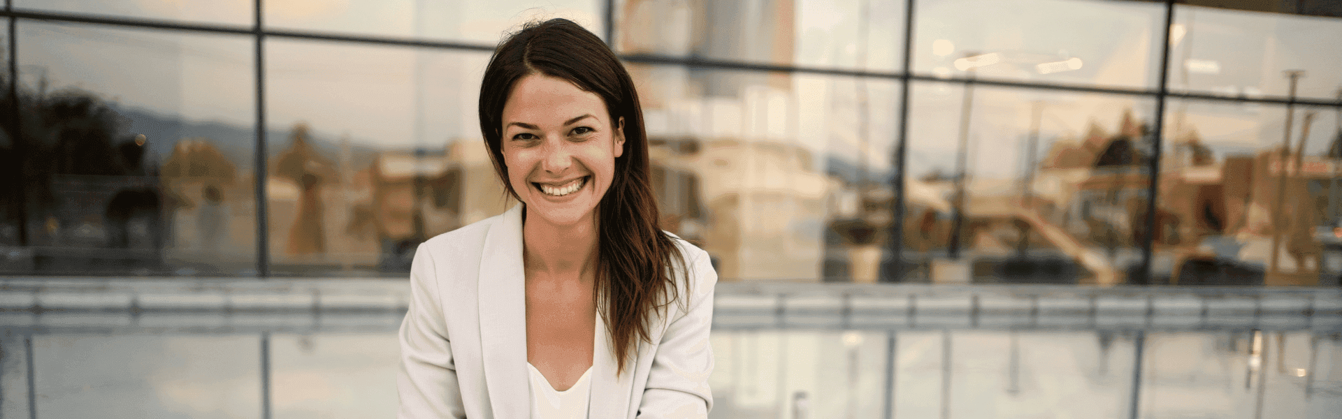 Geschäftsfrau sitzt vor Firmenfenster