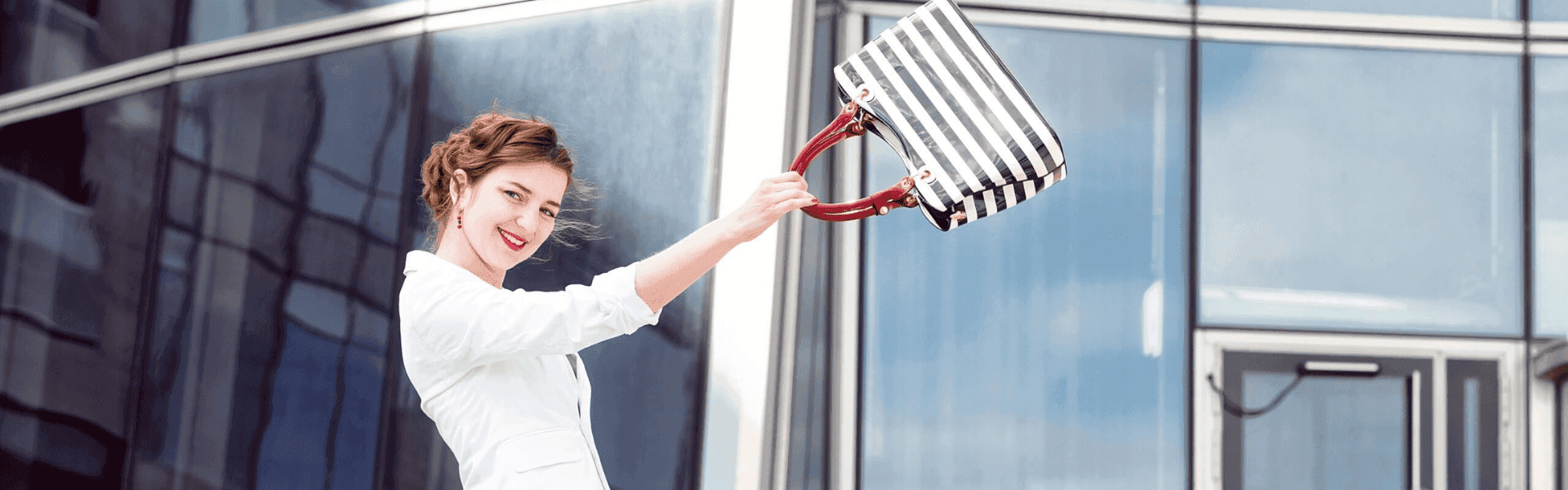 Erfolgsstrategien für höhere Arbeitsmotivation – Glückliche Businessfrau jubelt vor Bürogebäude. Tipps für mehr Produktivität, Zufriedenheit und Erfolg im Berufsleben.